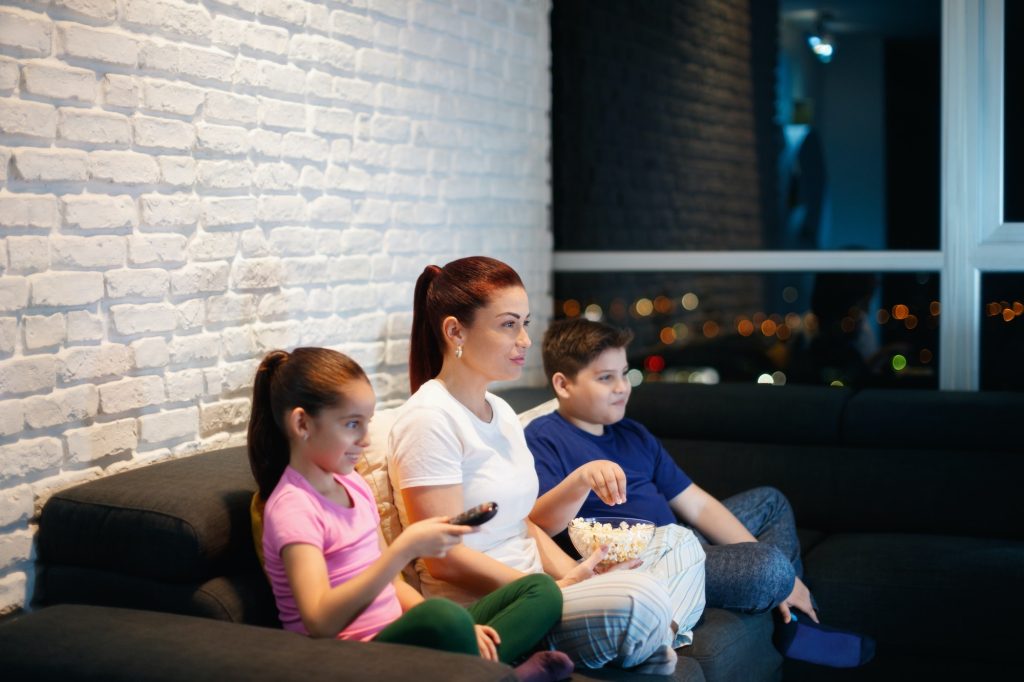 Single Mother And Children Watching TV At Night